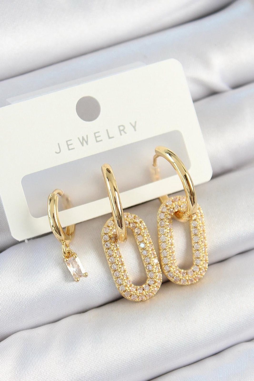 Asymmetrische goldfarbene Ohrringe mit funkelnden Zirkonia-Steinen